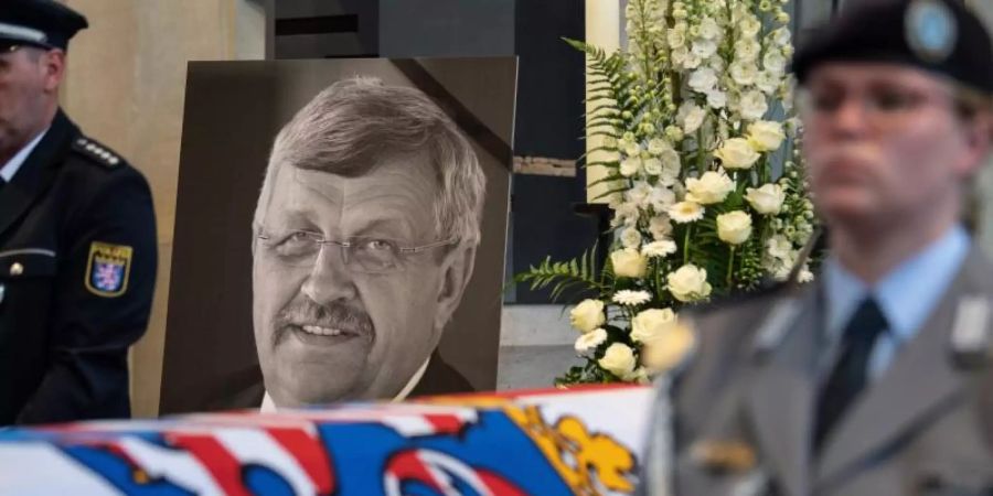 Das Konterfei von Walter Lübcke (CDU) hinter einem Bundeswehrsoldaten am Sarg bei einem Trauergottesdienst in der Martinskirche. Foto: Swen Pförtner/dpa