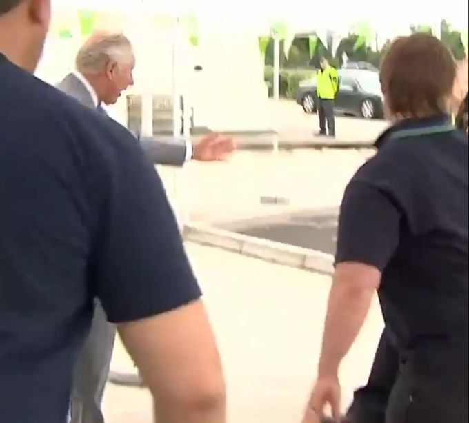 Prinz Charles streckt halbherzig den Arm aus. charles