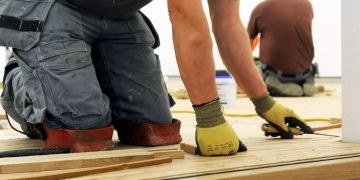 Mann auf Knien Arbeit Holz Baustelle