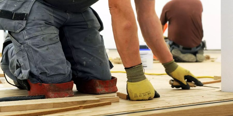 Mann auf Knien Arbeit Holz Baustelle