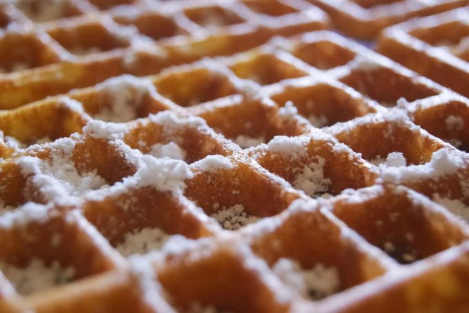 Quuadratisch, fluffig, schmackhaft: Belgische Waffeln mit Puderzucker. Nahaufnahme Belgische Waffel