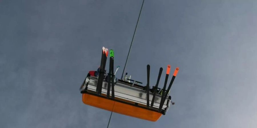 Skifahrer sind im Sessellift zum Zugspitzplatt unterwegs. Deutschlands höchstgelegenstes Skigebiet auf der Zugspitze ist am Freitag in die Wintersaison 2021/2022 gestartet. Foto: Angelika Warmuth/dpa