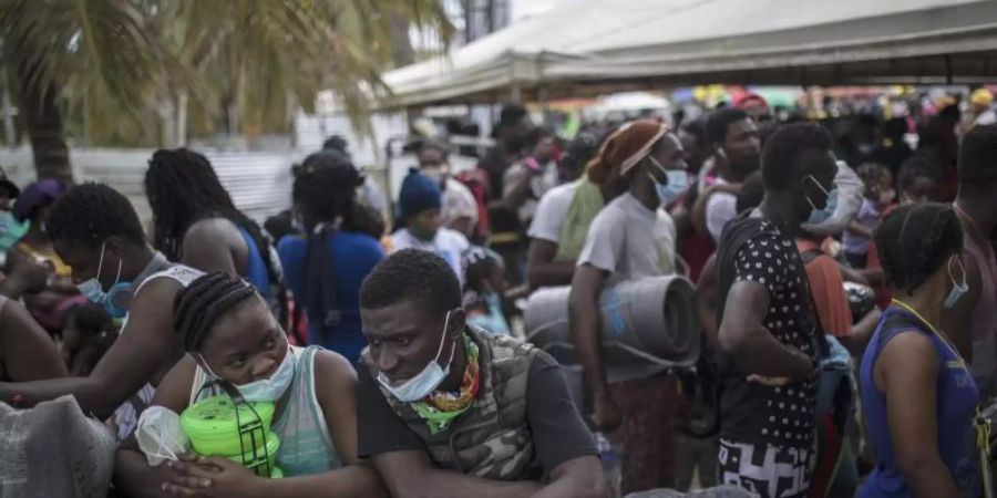 Haitianische Migranten warten darauf, an Bord eines Boots in Richtung Capurgana nahe der Grenze zu Panama zu gehen. Foto: Ivan Valencia/AP/dpa