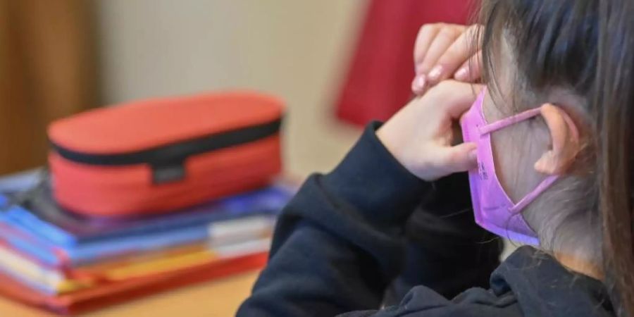 Ein Mädchen trägt eine Maske im Unterricht in einer Grundschule in Frankfurt (Oder). Foto: Patrick Pleul/dpa-Zentralbild/dpa