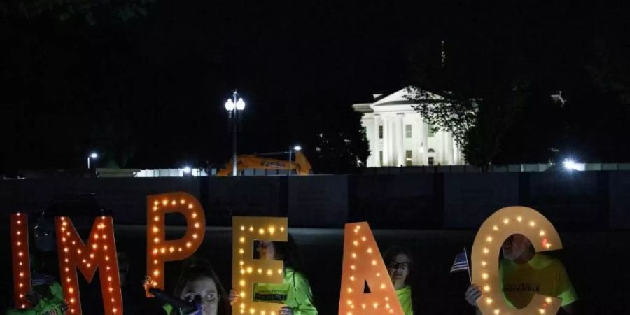 Demonstranten fordern vor dem Weissen Haus ein Amtsenthebungsverfahren gegen Donald Trump. Foto: Carolyn Kaster/AP