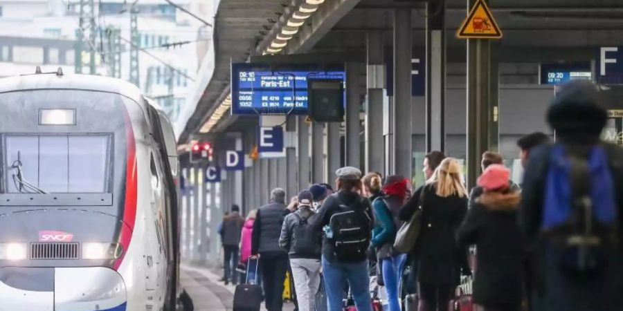 Zum Beginn des Reiseverkehrs zu den Weihnachtsfeiertagen, warten Fahrgäste am Stuttgarter Hauptbahnhof auf die Einfahrt eines TGV-Zuges mit Fahrtziel Paris. Foto: Christoph Schmidt/dpa