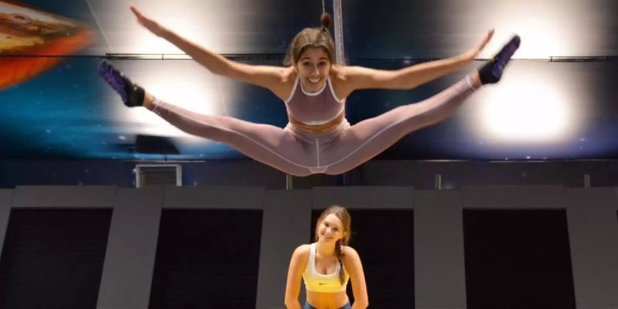 Die Geschwister Lilith (oben, 20) und Matilda (16) üben in der Trampolinhalle "Cosmic Arena". Foto: Jörn Perske/dpa