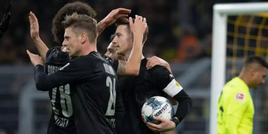 Dortmunds Torschütze Marco Reus (M) jubelt mit seinen Mannschaftskameraden Lukasz Piszczek und Axel Witsel über seinen Treffer zum 1:0. Foto: Bernd Thissen