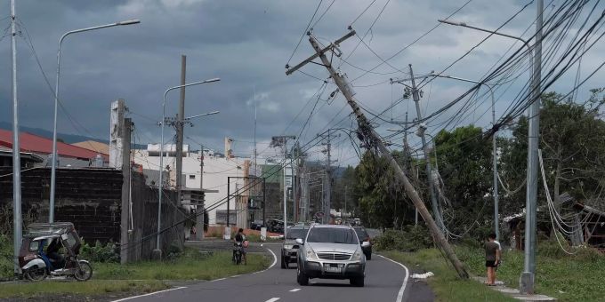 Umgeknickte Strommasten stehen neben einer Strasse in Legazpi. Philippinen Taifun