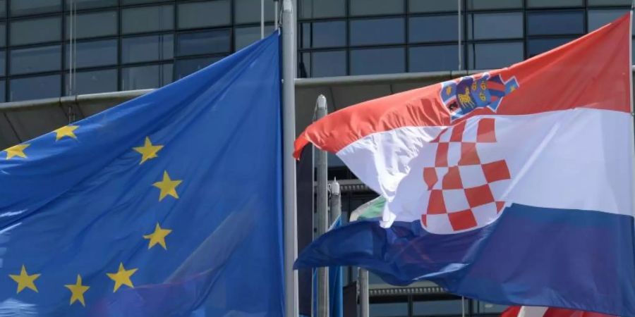 Die Flaggen der EU und Kroatiens vor dem Europäischen Parlament in Strassburg. Foto: Patrick Seeger/epa/dpa