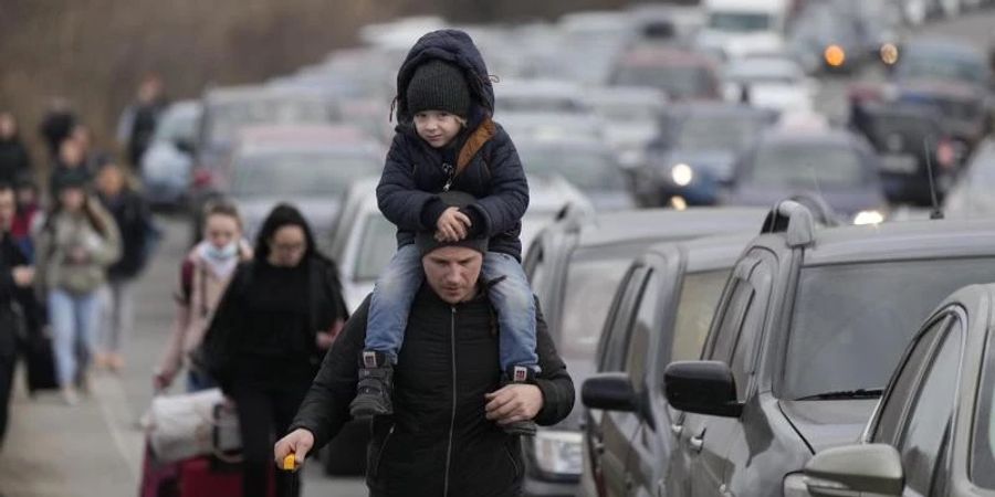 Aus der Ukraine geflüchtete Menschen am Grenzübergang Mayaky-Udobne. Wegen des russischen Angriffs auf ihre Heimat sind Hunderttausende auf der Flucht. Foto: Sergei Grits/AP/dpa