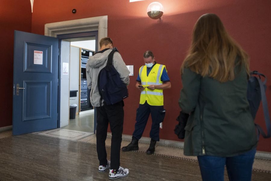 Ein Mann kontrolliert das Covid Zertifikat der Studenten anlässlich der Wiederaufnahme des Studienbetriebs mit Präsenzunterricht an der Universität Zürich, aufgenommen am Montag, 20. Septemb