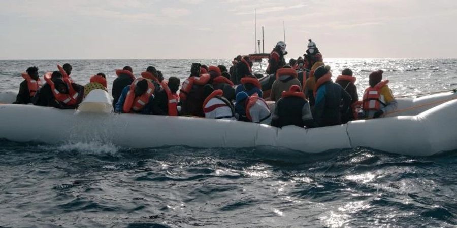 Menschen in einem in Not geratenen Boot auf dem Mittelmeer. Foto: Max Brugger/Sea-Watch/dpa