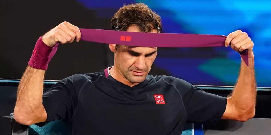 Roger Federer wechselt sein Stirnband.