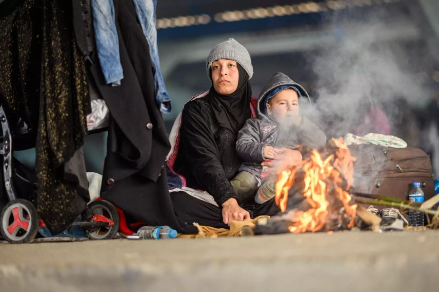 Eine Syrerin sitzt mit ihrem Kind in einer leeren Markthalle nahe der türkisch-griechischen Grenze. Die leere Markthalle wird von Flüchtlingen zur Übernachtung genutzt. Foto: Mohssen Assanim