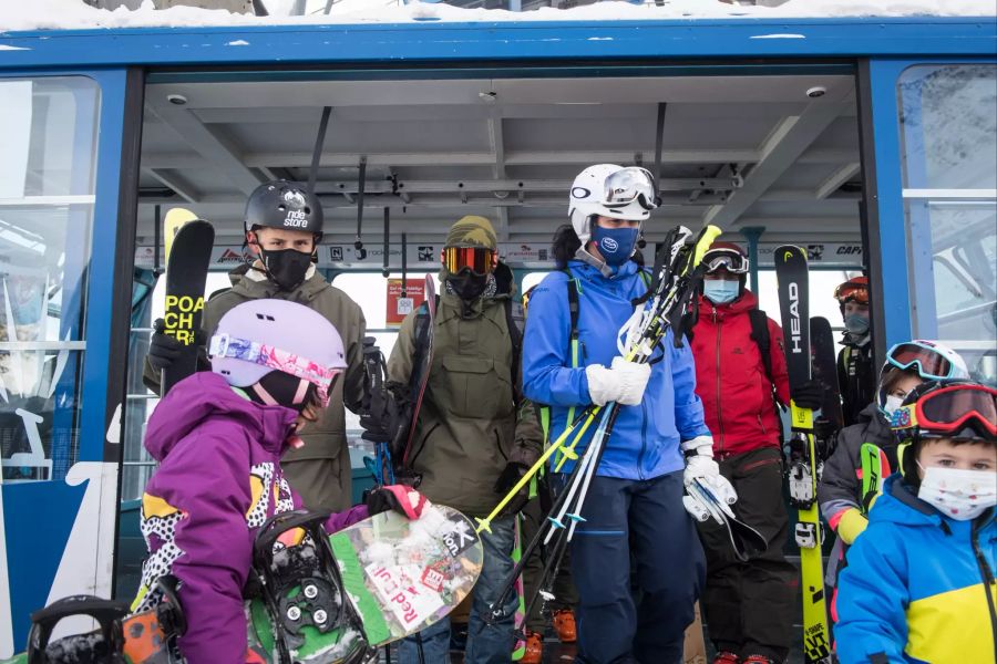 Wintersportler tragen Masken in den Gondeln. (KEYSTONE/Ti-Press/Alessandro Crinari)