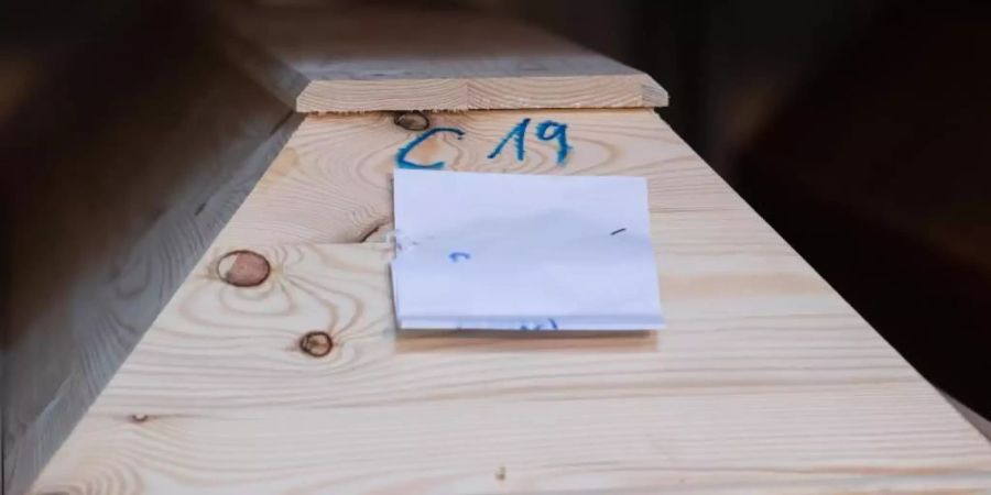 In einem Krematorium ist ein Sarg mit «C19» (für Covid-19) markiert. Foto: Julian Stratenschulte/dpa