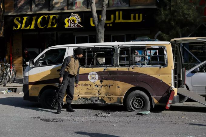 Ein Mann vom afghanischen Sicherheitsdienst überprüft ein Auto, das bei einem Raketenangriff in Kabul zerstört wurde. Raketenangriff in Kabul