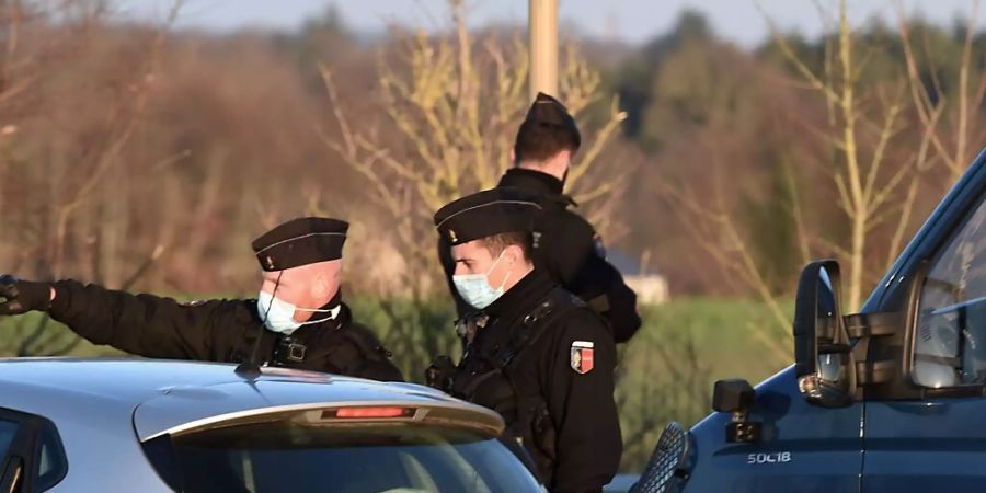 Gendarme blockieren den Zugang zum Veranstaltungsort einer Party. In Frankreich haben sich zum Jahreswechsel Tausende auf mehreren illegalen Grosspartys getroffen. Foto: Jean-Francois Monier/AFP/dpa