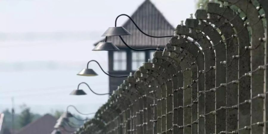 Stacheldrahtzäune und ein Wachturm auf dem Gelände des ehemaligen Vernichtungslagers Auschwitz-Birkenau. Foto: Armin Weigel/dpa