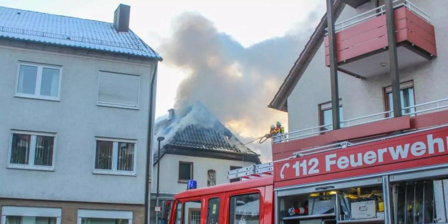 Einsatzkräfte der Feuerwehr löschen einen Brand in einem Wohnhaus in Kämpfelbach. Foto: Markus Rott/Einsatz-Report24/dpa