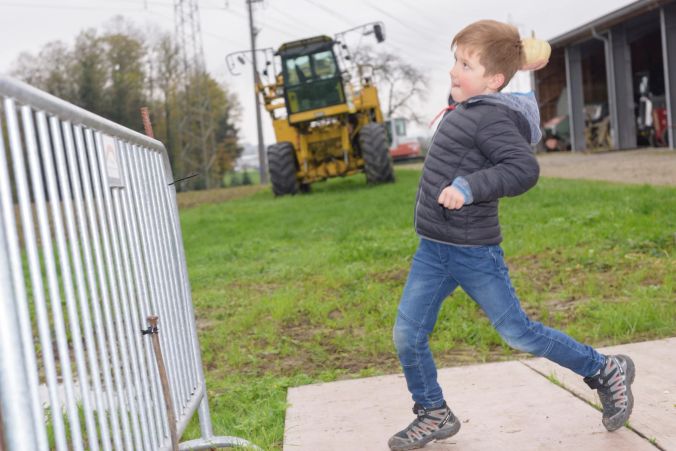 Luca wirft seinen Kürbis über die Abschrankung.