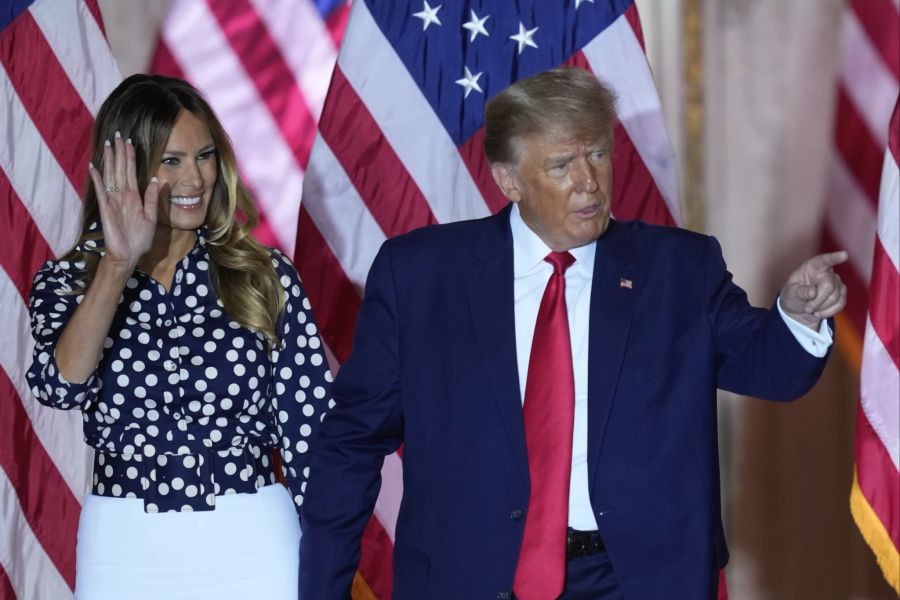 Melania Trump strahlt und hält mit Donald Händchen.