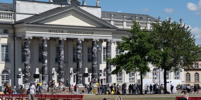 Besucher stehen vor dem Museum Fridericianum auf der documenta fifteen. Besucher stehen vor dem Museum Fridericianum auf der documenta fifteen.