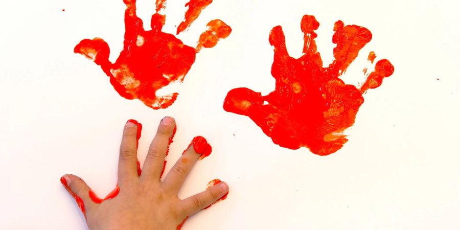 Pitsch, patsch, tolle rote Handabdrücke. In den Kinder-Mund kommt die Fingerfarbe aber besser nicht.
