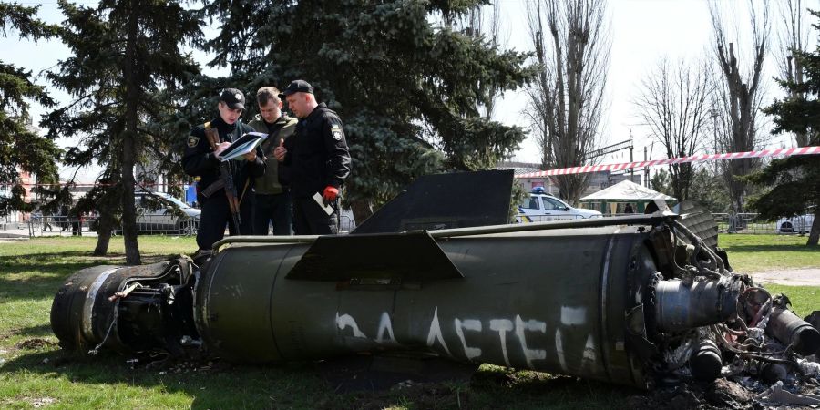 Ukrainische Soldaten während Ermittlungsarbeiten neben einem Fragment einer Tochka-U-Rakete mit der russischen Aufschrift «Für Kinder» nahe des Bahnhofs in Kramatorsk.