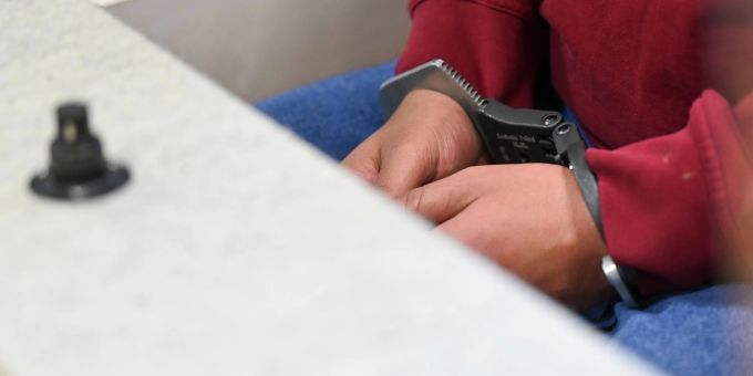 Der 31-jähriger Angeklagter sitzt in Handschellen im Gerichtssaal. Der 31-jähriger Angeklagter sitzt in Handschellen im Gerichtssaal.
