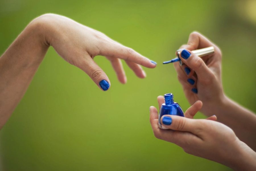 Hände Nagellack blau Fläschchen