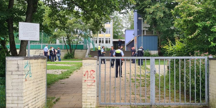 Einsatzkräfte stehen im Eingangsbereich einer Essener Realschule.