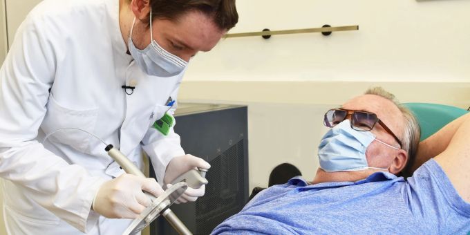 Nuklearmediziner Martin Heuschkel trägt radioaktive Paste beim Patienten Rainer Schnabel auf, die einen Hautkrebs-Tumor abtöten soll. Hautkrebs