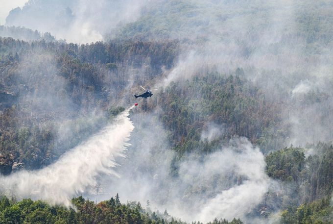 Ein Lösch-Hubschrauber der Bundespolizei über dem Waldbrand im Nationalpark Sächsische Schweiz. Robert Michael/dpa Waldbrand im Nationalpark Sächsische Schweiz