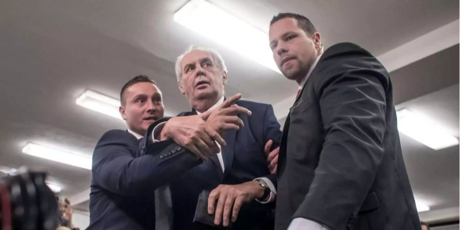 Milos Zeman wird von seinen Bodyguards in Sicherheit gebracht.