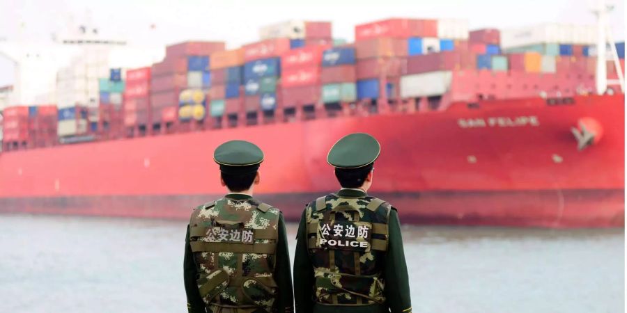 Chinesische Grenzpolizisten beobachten die Ankunft eines Containerschiffs.