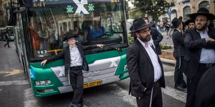 Ultra-orthodoxe jüdische Männer blockieren eine zentrale Kreuzung in Jerusalem während einer Demonstration gegen den Wehrdienst.