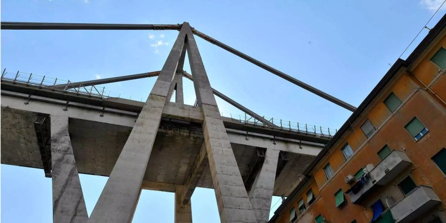 Blick auf die teilweise eingestürzte Morandi Autobahnbrücke über einem evakuierten Wohnhaus.