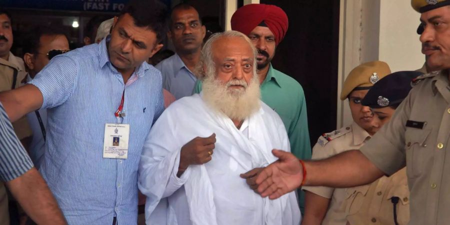 Der umstrittene spirituelle Guru, Asaram Bapu (M), wird von Polizisten am Jodhpur Flughafen begleitet. Ein Richter in der nordindischen Stadt Jodhpur sprach den Guru Asaram am Mittwoch schuldig.