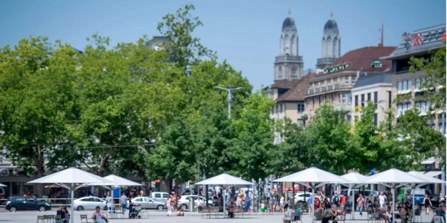 Leute geniessen ihre Mittagspause bei sommerlichen Temperaturen auf dem Sechseläutenplatz in Zürich, am Montag, 2. Juli 2018.