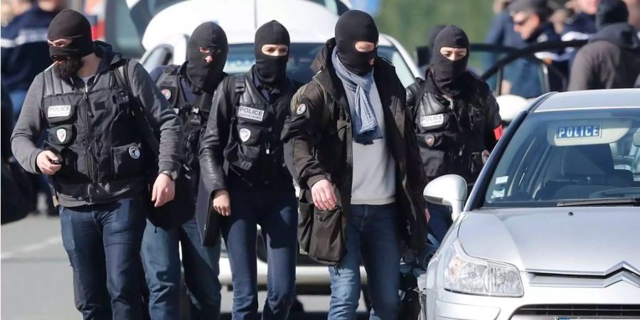 Maskierte Polizisten stehen beim Überfall auf den Super-U-Supermarkt in Südfrankreich im Einsatz.