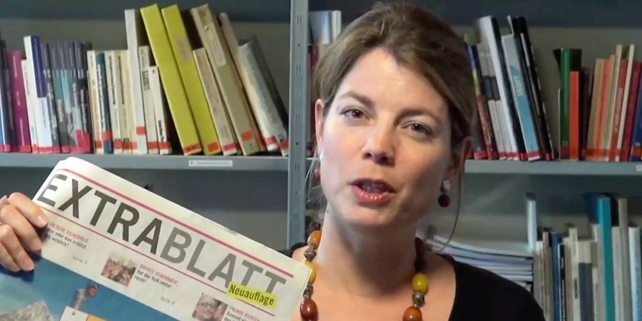 Manon Schick, Geschäftsleiterin der Schweizer Sektion von Amnesty International, mit einem Extrablatt im SVP-Layout.