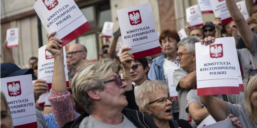 Demonstranten halten Deckblätter der polnischen Verfassung in ihren Händen.