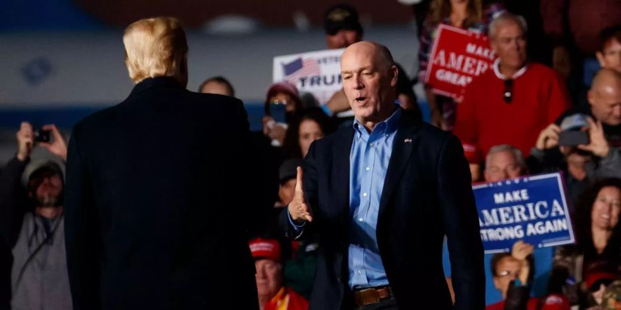 Greg Gianforte (r) wird auf einer Bühne von Donald Trump gegrüsst.