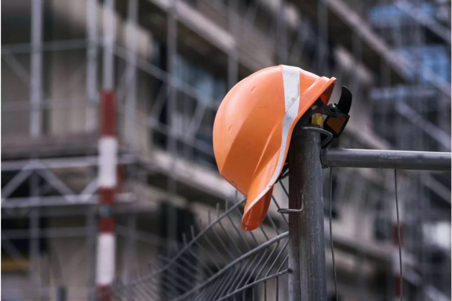 Bauarbeiterhelm auf einem Baugerüst - Keystone