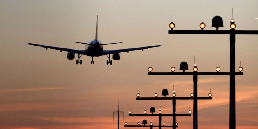 Ein Flugzeug ist während des Sonnenuntergangs im Landeanflug auf den Flughafen.