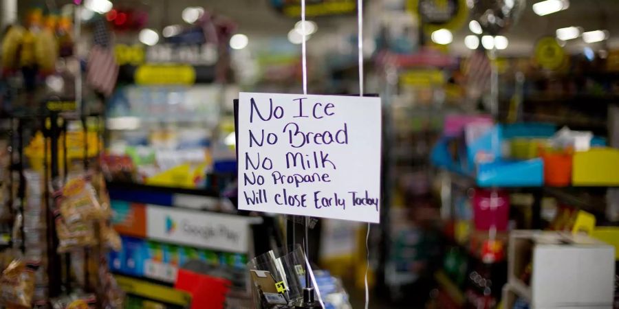 Auf einem Schild vor einem Laden steht, dass weder Eis, noch Brot oder Milch zu kaufen ist.