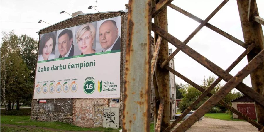 Ein Wahlplakat des regierenden Bündnisses der Grünen und Bauern von Ministerpräsident Maris Kucinskis mit der Aufschrift «Labo darbu campioni» (Champions der guten Arbeit) hängt an einer Hauswand in der lettischen Hauptstadt Riga.