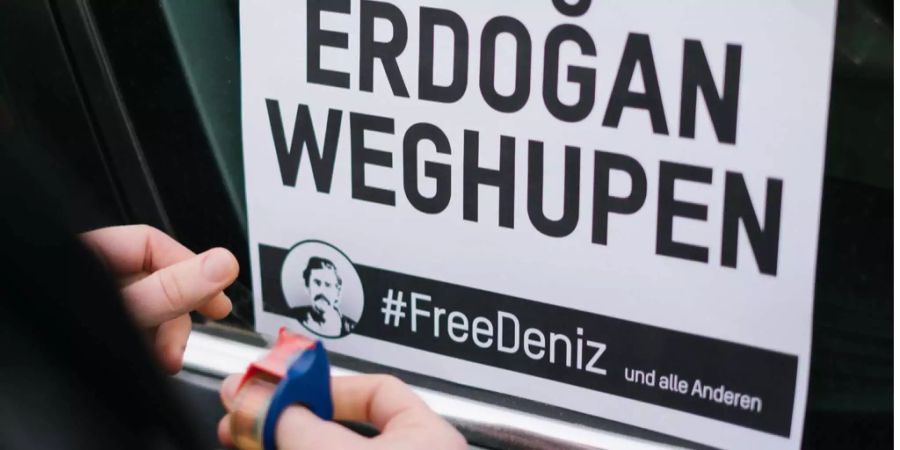 Ein Demonstranten beklebt sein Auto am 28.02.2017 in Hannover (Niedersachsen) vor Beginn eines Autokorsos der Initative #FreeDeniz für die Freilassung des in der Türkei festgehaltenen Journalisten Deniz Yücel, mit dem Slogan: "Erdogan Weghupen".